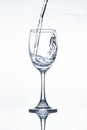 Water pouring into a vine glass on white Royalty Free Stock Photo