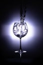 Water pouring into the wine glass on black reflective background, wine glass cup in which fresh water is poured Royalty Free Stock Photo