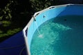 Water pours from a hose into a small round pool Royalty Free Stock Photo