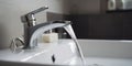 Water pours into sink from mixer in bathroom closeup. Royalty Free Stock Photo