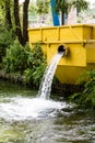 Water pours from yellow drainage pipe and machine