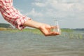 Water Purity Test. Hand holding chemical flask with liquid, lake or river in the background. Royalty Free Stock Photo