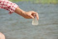 Water Purity Test. Hand holding chemical flask with liquid, lake or river in the background. Royalty Free Stock Photo