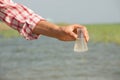 Water Purity Test. Hand holding chemical flask with liquid, lake or river in the background. Royalty Free Stock Photo