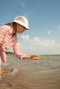 Water Purity Test. Woman holding chemical flask with water, lake or river in the background. Royalty Free Stock Photo