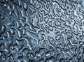 water from rain on a blue metallic steel surface making an abstract background pattern Royalty Free Stock Photo