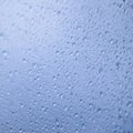 Water rain drops on blue glass surface as background. Abstract backdrop. Royalty Free Stock Photo