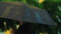 Water rain drops falling on black umbrella. Cloudy rainy season with thundershower, water drops falling on open parasol