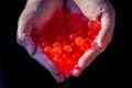 Water red gel balls. Small gel ball in the hand. Polymer gel. Silica gel. Balls of red hydrogel. Crystal liquid ball with reflecti