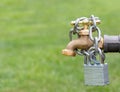 Outdoor water faucet with lock and chain. Royalty Free Stock Photo