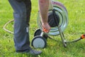 Water rubber pipe for gardening was rolled in the wheel reel equipment. Gardener wrap hose after watering Royalty Free Stock Photo