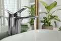 Water running from faucet into sink near mirror in bathroom Royalty Free Stock Photo