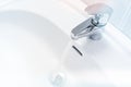 Water running from a faucet into a white sink Royalty Free Stock Photo