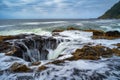 Water rushes into Thor's Well in Pacific Ocean at sunset in Oregon