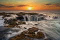 Water rushes into Thor's Well in Pacific Ocean at sunset in Oregon