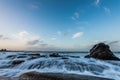 Water rushiing over rock on shelly beach Royalty Free Stock Photo