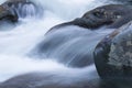 Water rushing over large rocks in a fast moving cold mountain stream Royalty Free Stock Photo