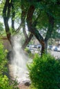 Water rushing up out of punctured hose, backlit