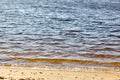 Water\'s edge on the shore. Wave of blue sea on sandy beach