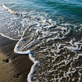 Between the water and sand indicates the ebb and flow of tides common in Royalty Free Stock Photo
