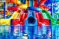 Water slide in the middle of pool filled with blue, red, yellow, and green water. AI Royalty Free Stock Photo