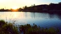 Water of the small lake slowly moving in sunset with small house on the shore