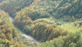 The water in a small mountain river with a rocky bottom is clear. On grassy meadows there are pastures, houses and farms. Trees gr