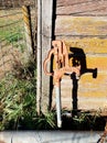 Water spigot outside of barn next to farm animals and fencing Royalty Free Stock Photo