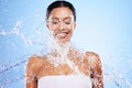 Water splash, black woman and beauty on blue background, skincare hydration and facial wellness, body care and shower Royalty Free Stock Photo