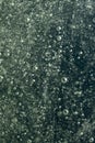 Water splash with bubbles on dark bokeh background, abstract texture. Royalty Free Stock Photo