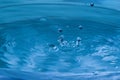 Water splash in dark blue color with a drop of water flying from Royalty Free Stock Photo