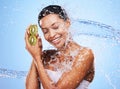 Water splash, kiwi and skincare of woman in studio isolated on a blue background. Healthcare, wellness and hygiene of