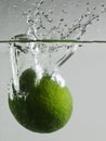 Water splash of lime dropping in water. Royalty Free Stock Photo