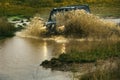 Water splash in off-road racing. SUV race on dirt. Wheel close up in a countryside landscape with a muddy road.