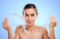 Water splash, portrait or woman with face wash for skincare, fresh body hygiene on blue background in studio. Girl model