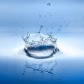 water splash with reflection and drops on a blue background Royalty Free Stock Photo