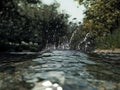 Water splash from a stream, surrounded by green nature Royalty Free Stock Photo
