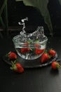 water splashed in a glass bowl with strawberries