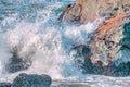 Water splashes close up. Crystal clear sea water beats against the rocks. Sea waves break on the stone shore of the ocean, blue