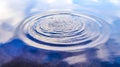 Water splashes and ripples on a water surface with a reflecting blue sky Royalty Free Stock Photo