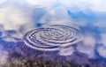 Water splashes and ripples on a water surface with a reflecting blue sky Royalty Free Stock Photo