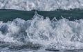 Water splashes on sea/ocean wave crest against blurred bac