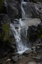 Water splashing off rocks with green moss