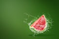 Water splashing on Sliced of watermelon on green background