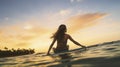 Water sport exercise surfing on summer vacation. A woman surfer paddling surfboard and riding the wave in the sea at tropical Royalty Free Stock Photo