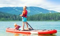 Two brothers swimming on stand up paddle board.Water sports , active lifestyle.