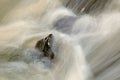 Water spray below small waterfall on mountain stream, water is falling over mossy boulder. The spray create on level and gravel mi Royalty Free Stock Photo