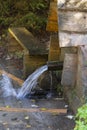 Water spring in the Carpathian mountains on a warm autumn day, closeup. West Ukraine. Wooden wellspring with clean drinking water Royalty Free Stock Photo