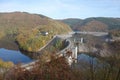 Water storage reservoir surrounded by forest . Seasonal autumnal trees and a lake . Barrage called Urfttalsperre next to Vogelsang Royalty Free Stock Photo