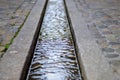 Water stream in formalised rill in pavement